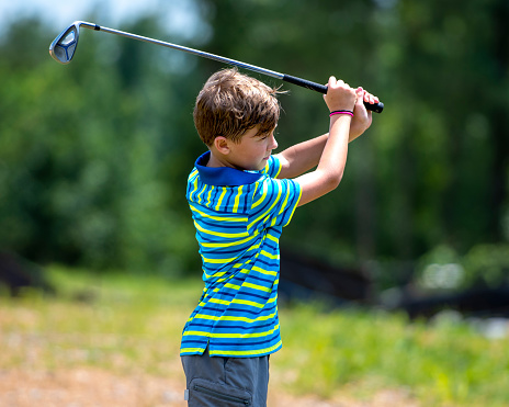 Boy Swinging A Golf Club