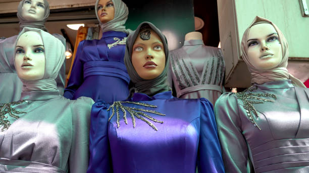Fashionable woman mannequins in store window through the glass in New York City wearing red.