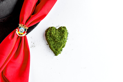 Yerba mate heart on white background and red gaucho scarf.