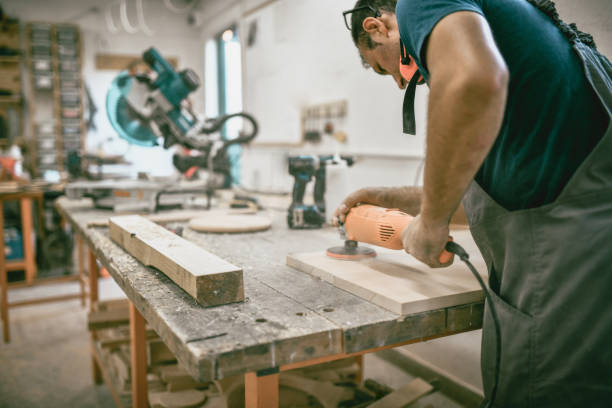 istock Rear View Of Carpenter Doing Last Polishing Touches On Plank In Workshop 1409951210