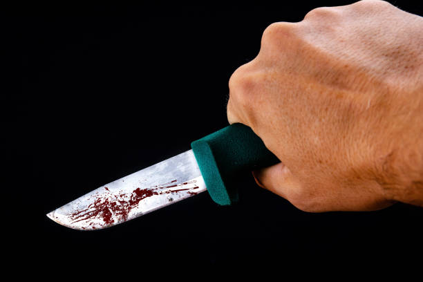 Small killer's knife in angry hand. Pickpocketing. Stealing. Crime and security concept. Thief with a knife is going to attack and rob another person. Gang member holding knife after murder. Knife Crime,Knife - Weapon,Blood,No People,Stained,Aggression Realistic knife stabbing on black background. Knife stabbing in the dark from the back with blood. Small pocket knife stabbing in the park. Army knife with blood on dark background. Blood on knife. Road rage. Combat knife. Ambush. Suspicious act switchblade stock pictures, royalty-free photos & images