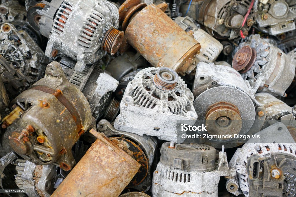 A pile of used car starters and generators, scrap electric motors A pile of rusty and oxidized used car starters and alternators, scrap electric motors Buying Stock Photo