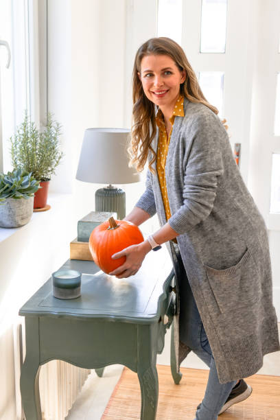 istock beautiful middle aged woman in home interior with pumpkin 1409953077