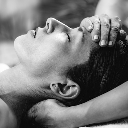 Cranial osteopathy massage. Therapist massaging woman’s head.