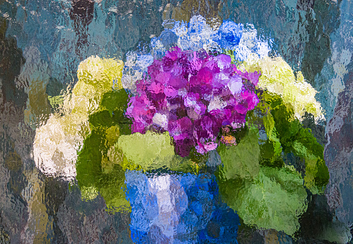 A vase of hydrangea flowers photographed through a sheet of textured art glass