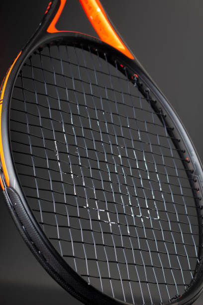 istock Black and orange tennis racket on a black background 1409955268