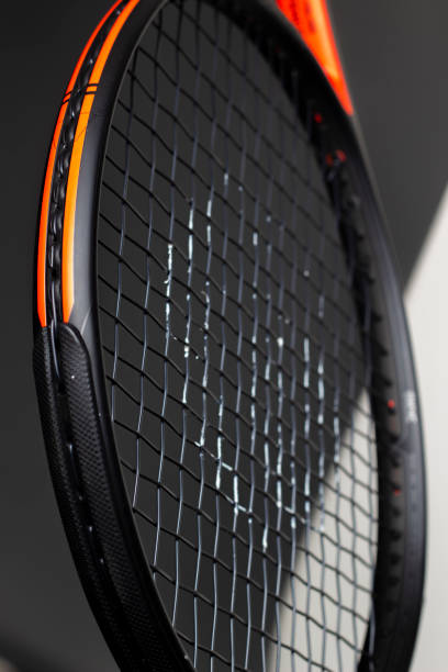 istock Black and orange tennis racket on a black background 1409955381
