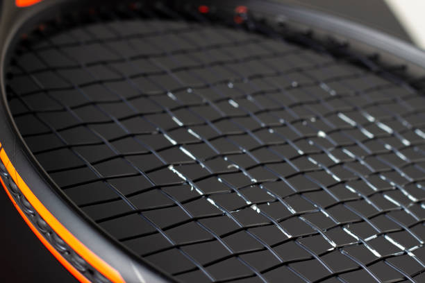 istock Black and orange tennis racket on a black background 1409955392
