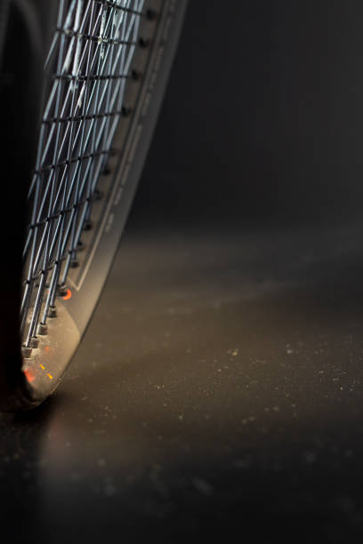 istock Black and orange tennis racket on a black background 1409955464