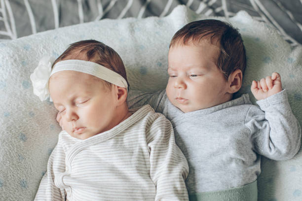 istock Cute Fraternal Twin Babies, Brother and Sister, lying on their back 1409957728