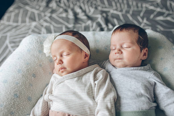 istock Cute Fraternal Twin Babies, Brother and Sister, lying on their back 1409957792