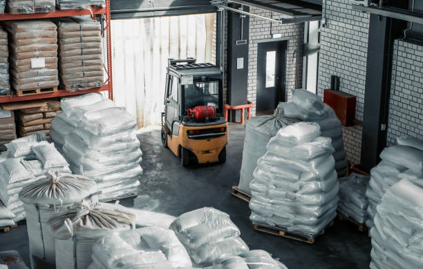 Forklift in warehouse with grain bags for export. Distribution and logistics concept stock photo
