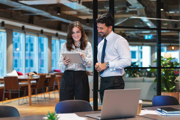 デジタルタブレットで一緒に働くビジネスマンと女性。 - formalwear women showing office ストックフォトと画像