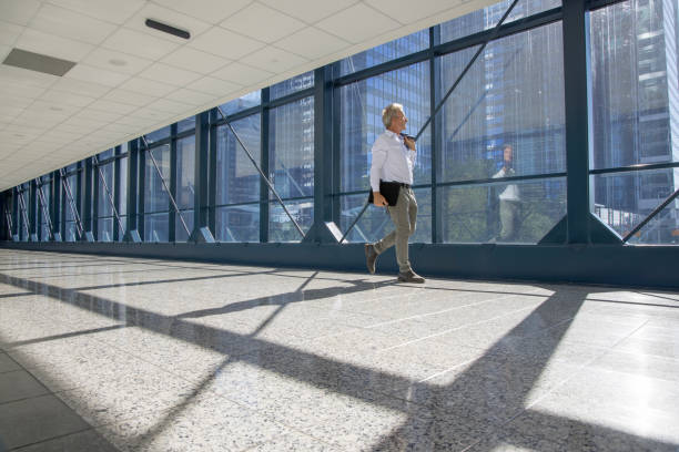 Business executive walks along urban corridor, business district behind