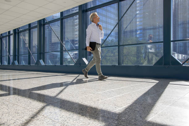 istock Business executive walks along urban corridor, business district behind 1409963339