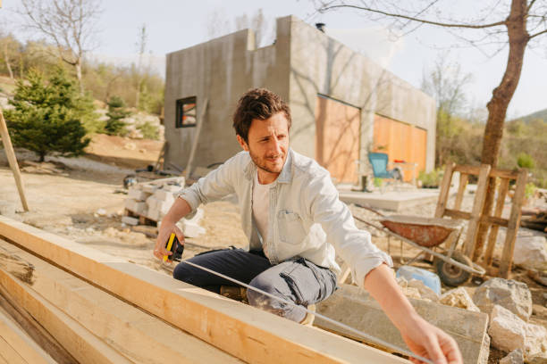 istock Carpenter arranging and measuring planks 1409967810