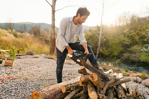 Photo of a man chopping firewood by himself for a winter season