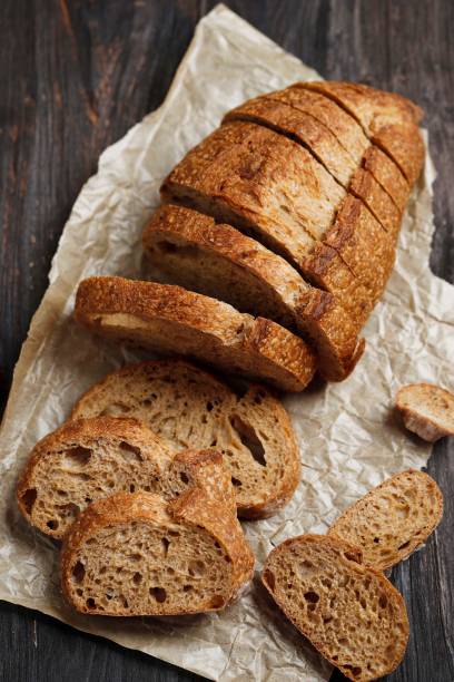 Sliced Rye Rustic Sourdough Bread on a Brown Paper. On a Wooden Table. T