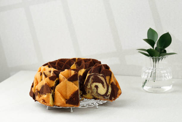 marble bundt cake sobre mesa de crema, fondo de sombra - chocolate bundt cake fotografías e imágenes de stock