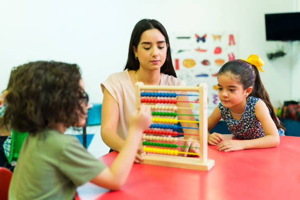 istock Preschool teacher teaching math with an abacus 1409980943