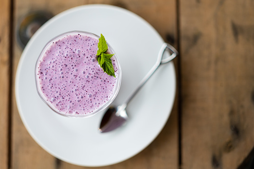 A top down view of a blueberry smoothie in a glass.