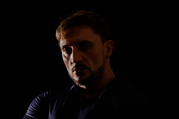 istock Young man portrait in high contrast dark background. 1409989838