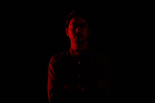 istock Young man portrait in high contrast dark background. 1409990399