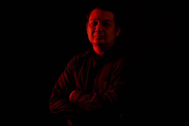 istock Young man portrait in high contrast dark background. 1409990442