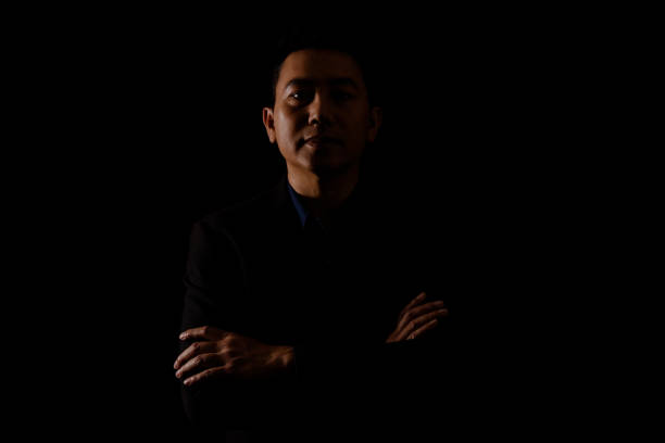 istock Young man portrait in high contrast dark background. 1409990541