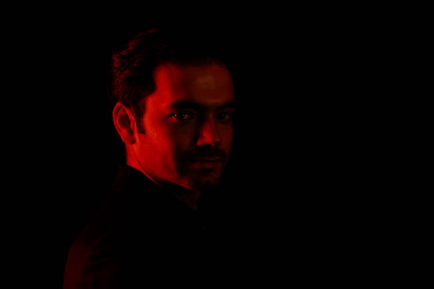 istock Young man portrait in high contrast dark background. 1409992344