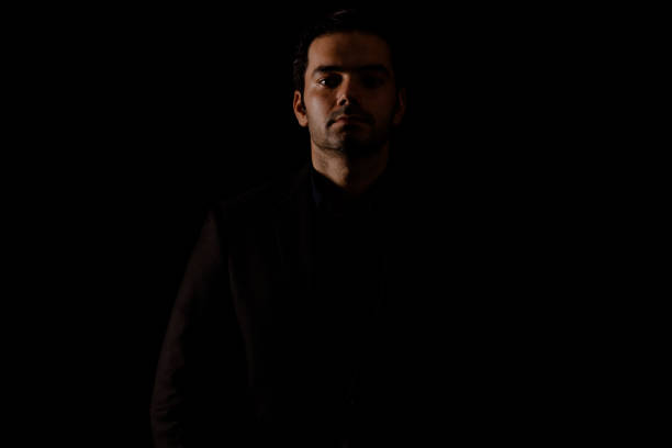 istock Young man portrait in high contrast dark background. 1409992353