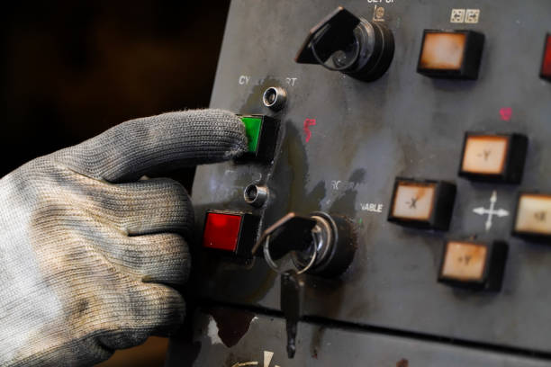 istock Dirty gloves press the green start button on the CNC machine control panel. 1409993893