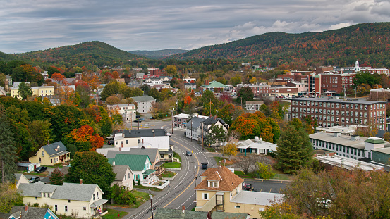 Aerial shot of Lebanon, a small city in Grafton County, New Hampshire on an overcast afternoon in autumn, with forests showing Fall colors on the surrounding hills.