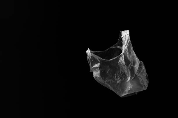 istock Side on view of single white floating plastic bag with black background. Plenty of copy space. 1410001972