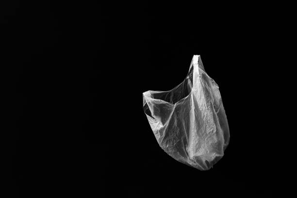 istock Side on view of single white floating plastic bag with water droplets with black background. Plenty of copy space. 1410001984