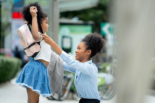 business woman dressed her sister before going to school in the morning. to before entering the school.