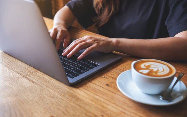 istock Closeup image of a woman working on laptop computer with coffee cup on the table 1410003088