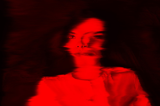 Fantasy, illusion and sci-fi concept. Abstract beautiful woman portrait in red neon futuristic glitch glowing hologram effect. Bright vivid filter applied. Pixel stretch and motion blur effect