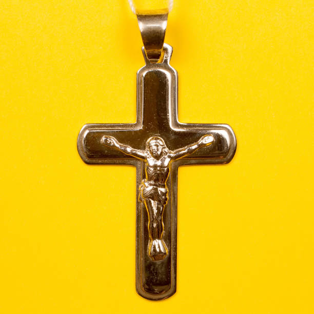 istock Silver Christian cross on a yellow background. 1410004505