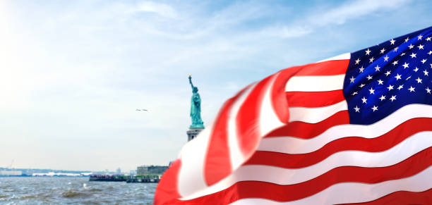 istock Statue of Liberty and American flag 1410007285