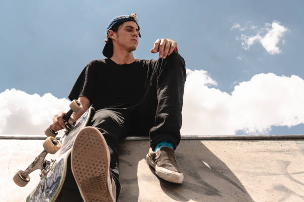 istock A young skateboarder sitting on a ramp posing with his skateboard in his hand 1410008251