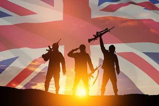 Silhouettes of soldiers on a background of United Kingdom flag. Greeting card for Poppy Day, Remembrance Day. United Kingdom celebration.