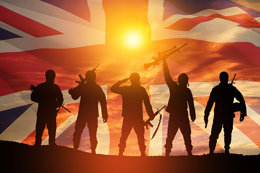Silhouettes of soldiers on a background of United Kingdom flag. Greeting card for Poppy Day, Remembrance Day. United Kingdom celebration.