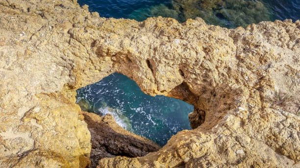 istock Heart shape sandstone formation at the coast. View into blue sea. 1410010047