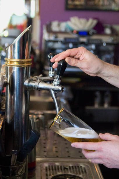 istock Bartender pours cold beer into glass from tap 1410010947