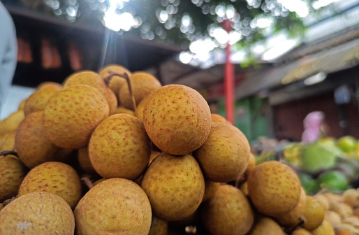 a pile of ripe longan fruit, the skin is brown