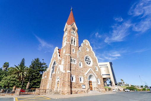 Christ Church (Christuskirche) on Robert Mugabe Avenue in Windhoek at Khomas Region, Namibia, with a commercial sign visible as well as people.