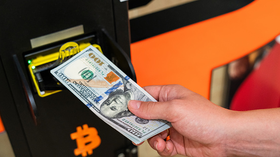Atm bitcoin cryptocurrency machine. Woman withdraw american dollar bill cash. Usd hundred money payment on virtual crypto currency btc wallet. Bitcoin BTC ATM Cash Machine
