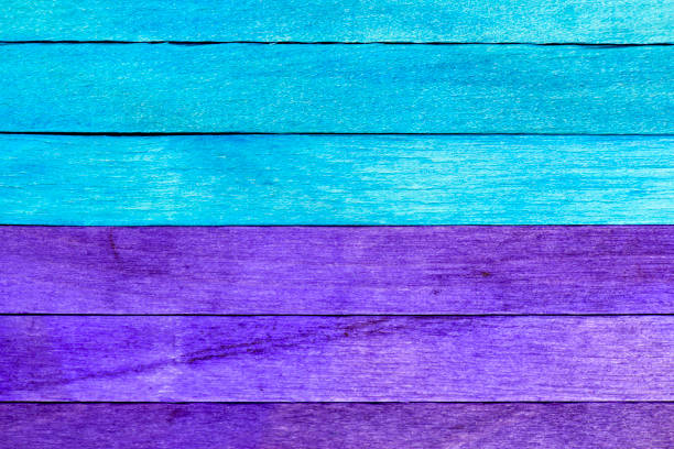 Bright background from purple and blue wooden planks. Wooden textured background with natural patterns. Blue and purple painted wooden boards arranged horizontally in a row and separated into two parts.
