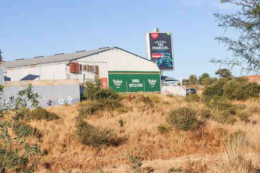 Commercial signs and graffiti visible outside Namica Supermarket Retail & Wholesale on Ondoto Street at Okuryangava in Katutura Township near Windhoek, Namibia